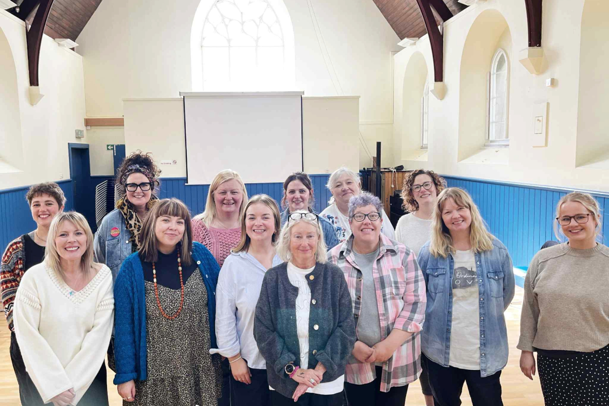 A group of 13 people smiling at the camera