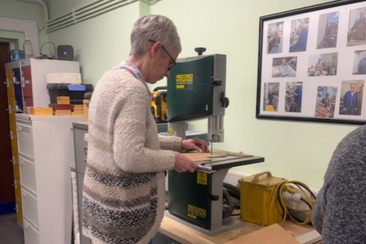 A person using an angle cutter to shape wood