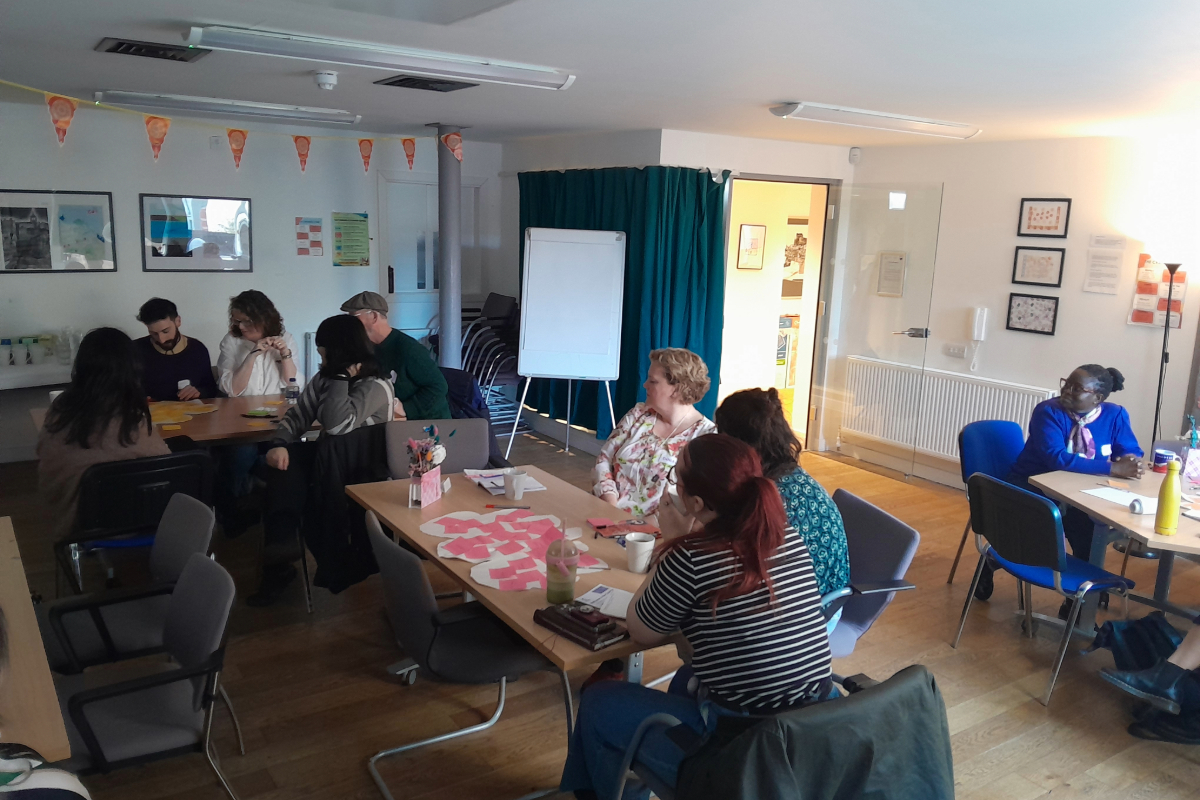 3 tables in a room with group of people sitting at each
